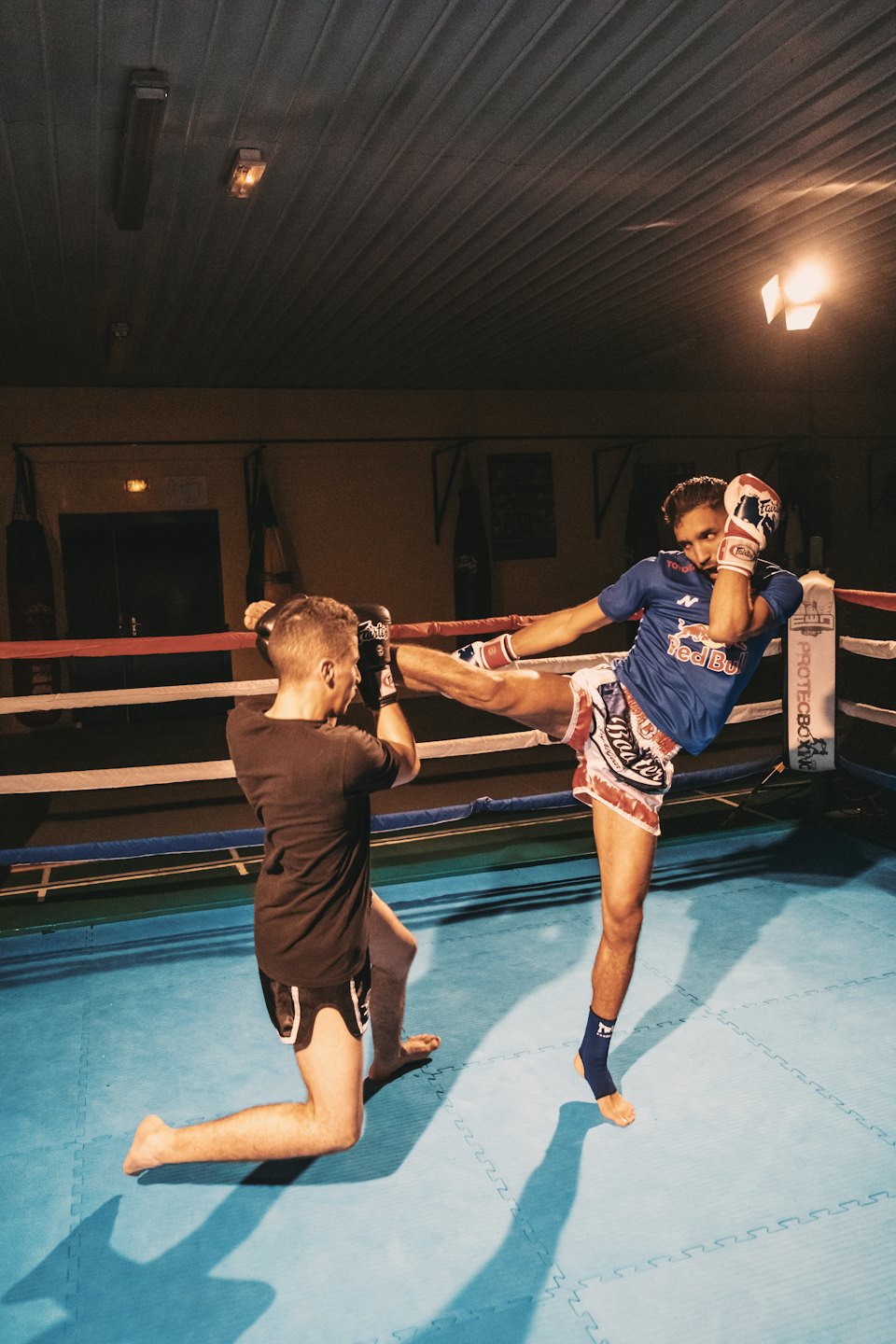 Two men training Muay Thai in a boxing ring.